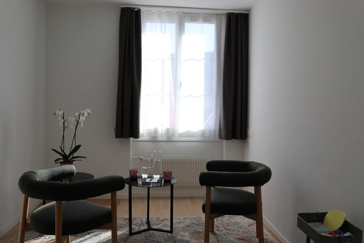 Ein Zimmer mit zwei Stühlen und einem kleinen Tisch
